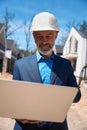 Male geodesist checking landscape and lie of ground using laptop