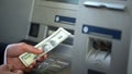 Male getting dollars from automatic teller machine, cash withdrawing, banking