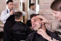 Male getting shave with straight razor in salon