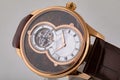 Male golden wristwatch with white dials, golden clockwise, stopwatch, on brown leather strap isolated on white background.