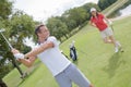 Male golf instructor teaching female golf player