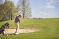 Male golf player pitching on course. Royalty Free Stock Photo