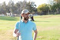 male golf player on professional golf course. portrait of golfer in cap with golf club. Royalty Free Stock Photo