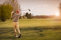 Male golf player at sunset.