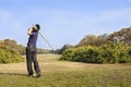 Male golf player teeing off golf ball from tee box Royalty Free Stock Photo