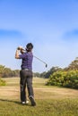 Male golf player teeing off golf ball from tee box Royalty Free Stock Photo