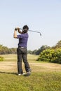 Male golf player teeing off golf ball from tee box Royalty Free Stock Photo