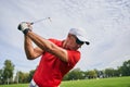 Male golfer doing a golf swing outdoors Royalty Free Stock Photo