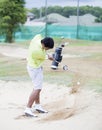 Male golfer hitting golf ball out of a sand trap Royalty Free Stock Photo