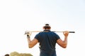 Male golfer holding driver while standing on green course Royalty Free Stock Photo