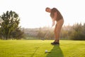 Male Golfer Putting Ball Into Hole On Green Royalty Free Stock Photo