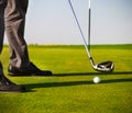 Male golfer putting, focus on golf ball Royalty Free Stock Photo
