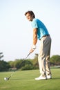 Male Golfer Teeing Off