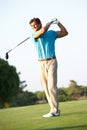 Male Golfer Teeing Off On Golf Course