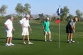 Male golfers on putting green.