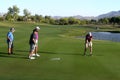 Male golfers on putting green.