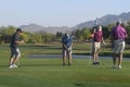 Male golfers on putting green.