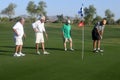 Male golfers on putting green.