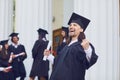 Male graduate is smiling against the background of university graduates. Royalty Free Stock Photo