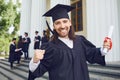 Male graduate is smiling against the background of university graduates. Royalty Free Stock Photo