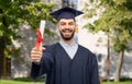 male graduate student in mortar board with diploma