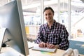 Male graphic designer looking at camera while working on computer at desk in a modern office Royalty Free Stock Photo