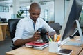 Male graphic designer reviewing captured images in his digital camera at desk