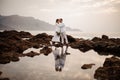 Male groom and female bride standing on the stone beach with the bouquet Royalty Free Stock Photo