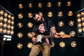 Male guitarist on stage with decorations of lights Royalty Free Stock Photo