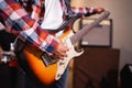 a male guitarist strums the strings of an electric guitar while tuning before being used Royalty Free Stock Photo