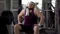 Male in gym pretending to be athletic, sitting as macho, workout motivation