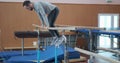 Gymnast doing workout on parallel bars at gym