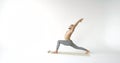 Male gymnast is training alone in white room, stretching hands and legs, warming