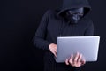 Male hacker with black mask carrying laptop Royalty Free Stock Photo