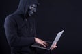 Male hacker with black mask carrying laptop Royalty Free Stock Photo