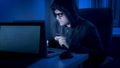 Male hacker in hood stealing money from credit card at night Royalty Free Stock Photo