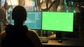 Male hacker using greenscreen display to hack online server
