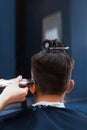 Male haircut with electric razor back shot. Barber makes haircut for client at the barber shop by using hair clipper.