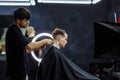 Male haircut with electric razor. Barber makes haircut for client at the barber shop by using hairclipper. Man
