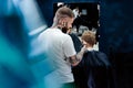 Male haircut with electric razor. Tattooed Barber makes haircut for client at the barber shop by using hairclipper. Man Royalty Free Stock Photo