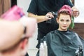 Male hairdresser applying water spray on female client`s hair.