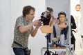 A male hairdresser prepares an image for a competition on a mannequin with a wig