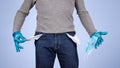 Male half body view. Protected man with gloves and surgical mask, shows the pockets of his empty pants. Concept of crisis and Royalty Free Stock Photo