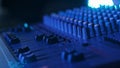 Male Hand Adjusting Faders Up And Down on Audio Mixer in Neon Light Close-Up