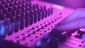 Male Hand Adjusting Faders Up And Down on Audio Mixer in Neon Light Close-Up