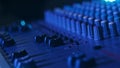 Male Hand Adjusting Faders Up And Down on Audio Mixer in Neon Light Close-Up
