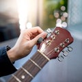Male hand adjusting pegs on acoustic guitar Royalty Free Stock Photo