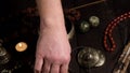 Male hand arranges religious items of prayers and meditations on the table