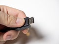 In the male hand is a black hdmi cable. Cable for connecting devices