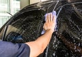 Male hand with blue cloth washing a car at home Royalty Free Stock Photo